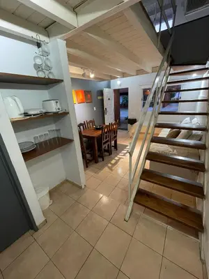 a staircase in a room with a table and chairs at Aparts Costalago in Villa Carlos Paz