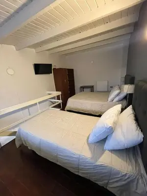 a bedroom with two beds and a television in it at Aparts Costalago in Villa Carlos Paz