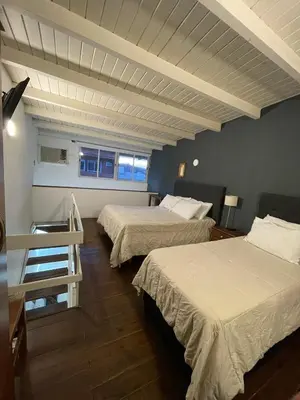 a hotel room with two beds and a staircase at Aparts Costalago in Villa Carlos Paz