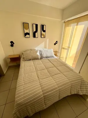 a bed in a bedroom with two pictures on the wall at Dean Funes Apartamento in Cordoba