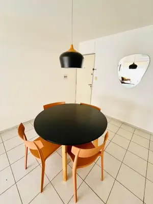 a dining room table with two chairs and aendant light at Dean Funes Apartamento in Cordoba
