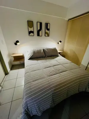 a bedroom with a bed with two lamps on the wall at Dean Funes Apartamento in Cordoba