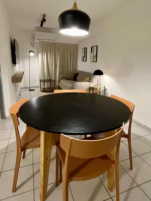 a dining room table and chairs in a living room at Dean Funes Apartamento in Cordoba