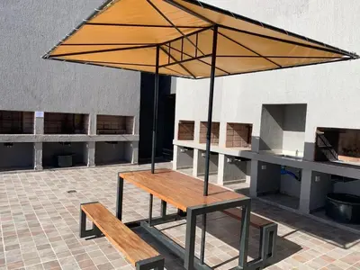 a picnic table with an umbrella on top of it at Miralejos 7 Centro in Villa Carlos Paz