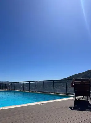 a bench sitting on a boardwalk next to a swimming pool at Miralejos 7 Centro in Villa Carlos Paz