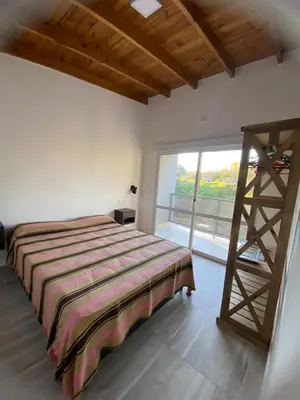 a bedroom with a bed and a large window at Cuatro vientos 2 in Santa Rosa de Calamuchita