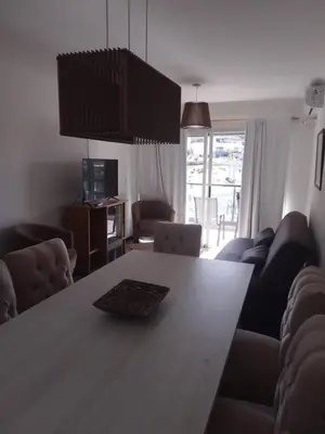 a living room with a large wooden table with chairs at Veneto Village Departamento in Villa Parque Siquiman
