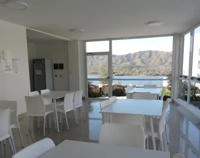 a dining room with tables and chairs and a view of the water at Veneto Village Departamento in Villa Parque Siquiman