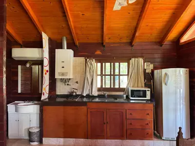 a kitchen with a refrigerator and a sink in a room at Complejo Costario in Tanti