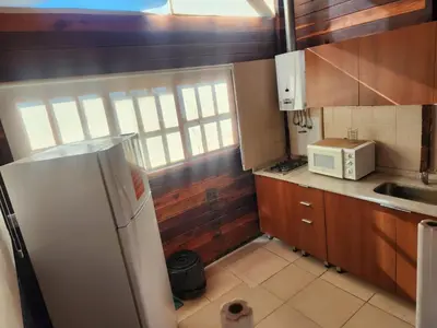 a small kitchen with a refrigerator and a microwave at Complejo Costario in Tanti
