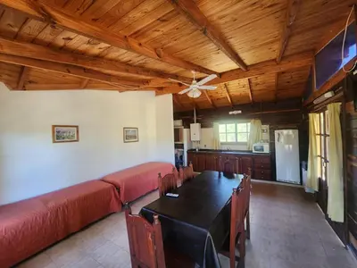 a dining room with a table and a couch at Complejo Costario in Tanti