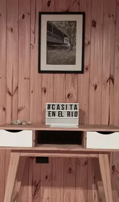 a shelf with a picture on a wooden wall at Casita en el río, Mayu Sumaj in San Antonio de Arredondo