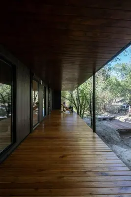 a wooden boardwalk leading to a house with windows at Casita en el río, Mayu Sumaj in San Antonio de Arredondo