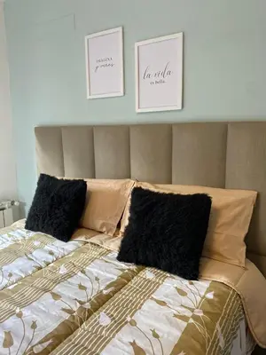 a bed with two pillows and two pictures on the wall at Descanso de Liniers in Alta Gracia