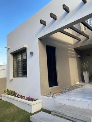 a white house with a window and some flowers at Descanso de Liniers in Alta Gracia