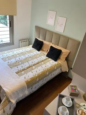 a large bed in a room with a table at Descanso de Liniers in Alta Gracia
