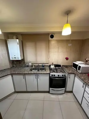 a kitchen with a stove and a microwave at Lugones House in Cordoba