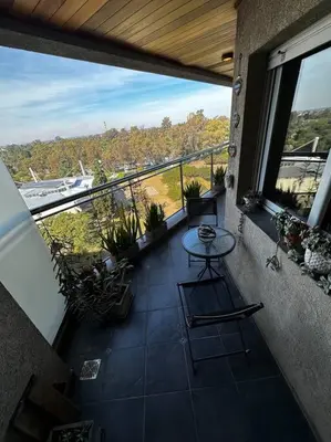 a balcony with a table and a view of a boat at Lugones House in Cordoba