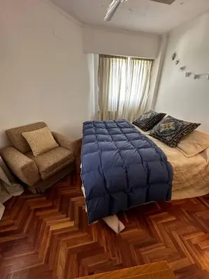 a bedroom with a large bed and a chair at Lugones House in Cordoba