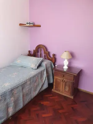 a bedroom with a bed and a table with a lamp at Rosa de los Vientos - Duarte Quirós in Cordoba