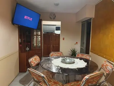 a dining room with a table and chairs and a tv at Rosa de los Vientos - Duarte Quirós in Cordoba