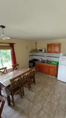 a kitchen with a wooden table and a refrigerator at Complejo BETELGEUSE in La Estancia