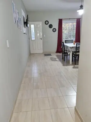a living room with a tiled floor and a dining room at Hermoso Departamento en Quines in Quines