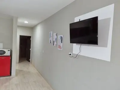 a flat screen tv hanging on a white wall at Hermoso Departamento en Quines in Quines