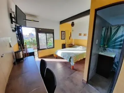a bedroom with a bed and a table and chairs at El fogón de los amigos in Villa Carlos Paz