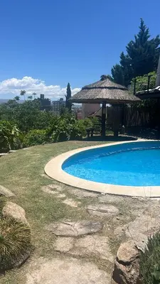 a swimming pool with a gazebo in a yard at El fogón de los amigos in Villa Carlos Paz