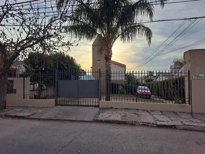 a fence with a palm tree and a car behind it at Dpto BenRos 5 pax - Complejo el Escorial in Villa Carlos Paz