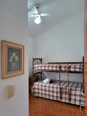 a room with two bunk beds and a ceiling fan at Dpto BenRos 5 pax - Complejo el Escorial in Villa Carlos Paz