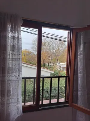 a window with a view of a yard at Dpto BenRos 5 pax - Complejo el Escorial in Villa Carlos Paz