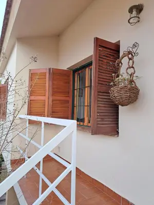 a house with a window and a basket on the wall at Dpto BenRos 5 pax - Complejo el Escorial in Villa Carlos Paz