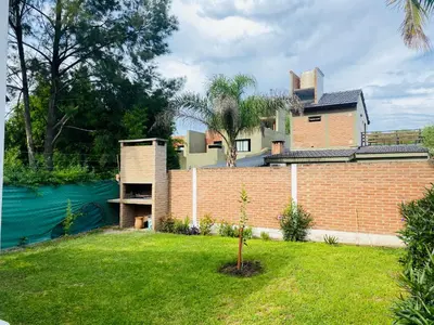 a house with a brick wall next to a river at Casa Ayacucho in Alta Gracia