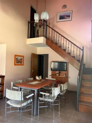 a dining room with a table and chairs and a staircase at El Recuerdo in Merlo