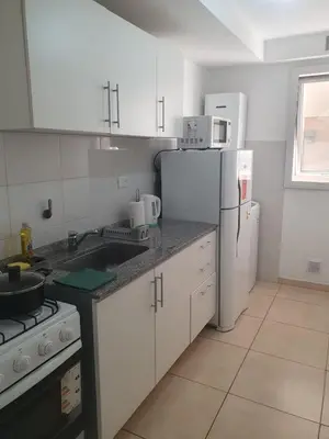 a kitchen with white cabinets and a white refrigerator at Lo de Tony in Cordoba