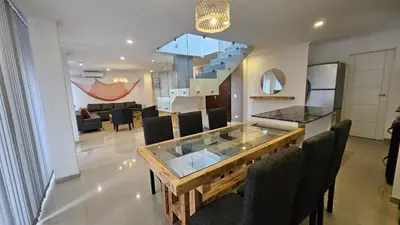 a dining room and living room with a glass table and chairs at Penthouse Calazans in Cordoba