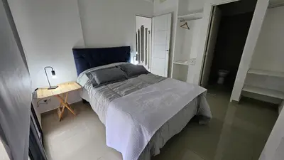 a bedroom with a bed and a table and stairs at Penthouse Calazans in Cordoba