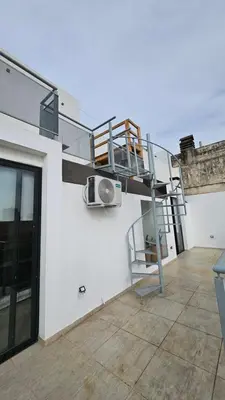 a spiral staircase on the side of a white building at Penthouse Calazans in Cordoba