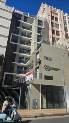 a man riding a scooter in front of a building at Penthouse Calazans in Cordoba
