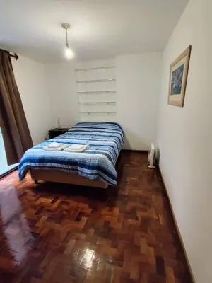a bedroom with a bed and a wooden floor at Balcarce Residential Apartament in Cordoba