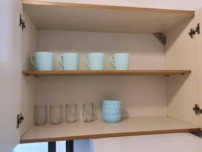 a shelf with blue bowls and cups on it at Balcarce Residential Apartament in Cordoba