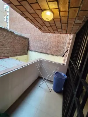 a small balcony with a trash can and a basket at Balcarce Residential Apartament in Cordoba