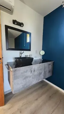 a bathroom with a sink and a mirror on a wall at Cabañas La Frontera in Villa General Belgrano