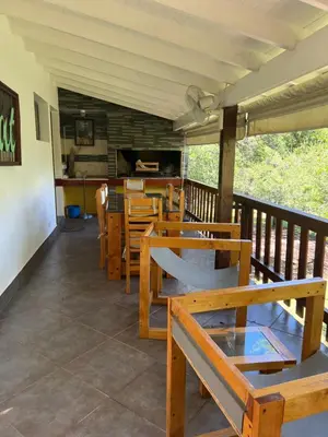 a restaurant with wooden tables and chairs on a balcony at Cabañas La Frontera in Villa General Belgrano