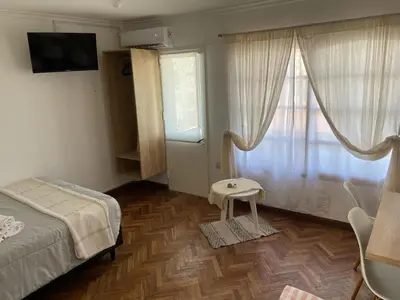 a bedroom with a bed and a table and a window at A metros de PATIO OLMOS in Cordoba