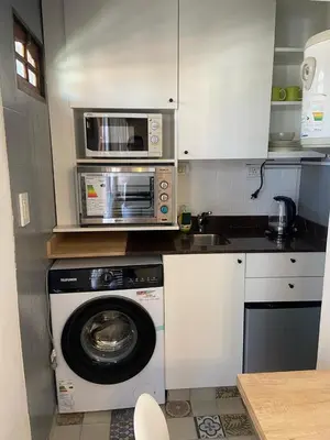a kitchen with a washing machine and a microwave at A metros de PATIO OLMOS in Cordoba