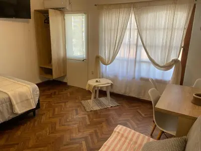 a bedroom with a bed and a table and a window at A metros de PATIO OLMOS in Cordoba