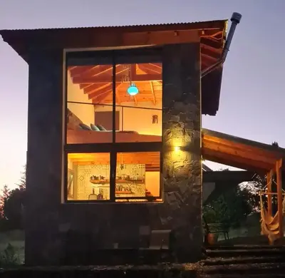 a view of a house through a window at Eco Refugio in Los Reartes